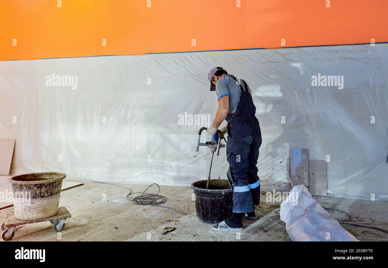 l'uomo pone il gres su un luogo di costruzione Foto Stock