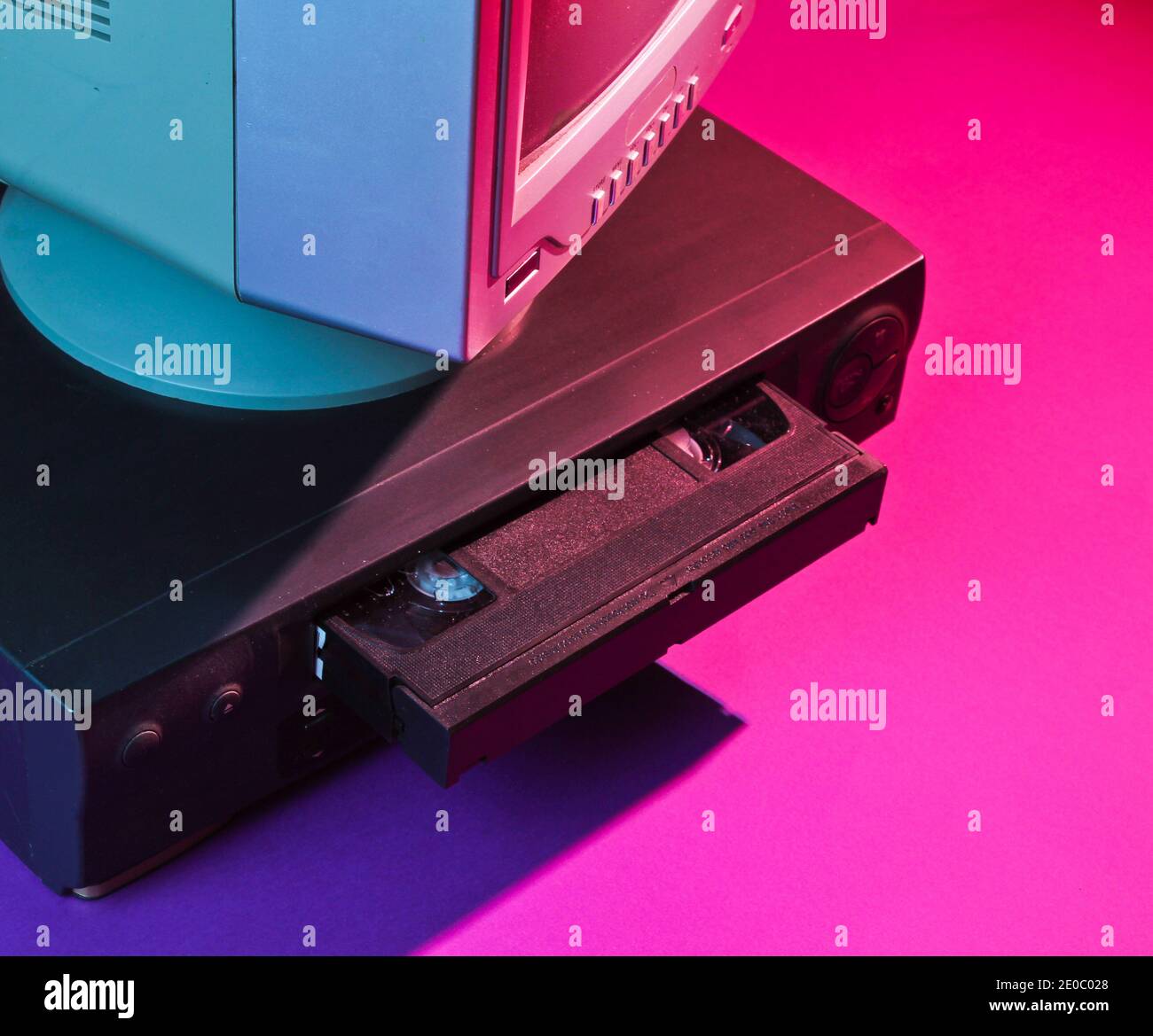 Onda retrò, concetto anni '80. Lettore video con cassetta vhs, vecchio tv, luce al neon. Foto Stock