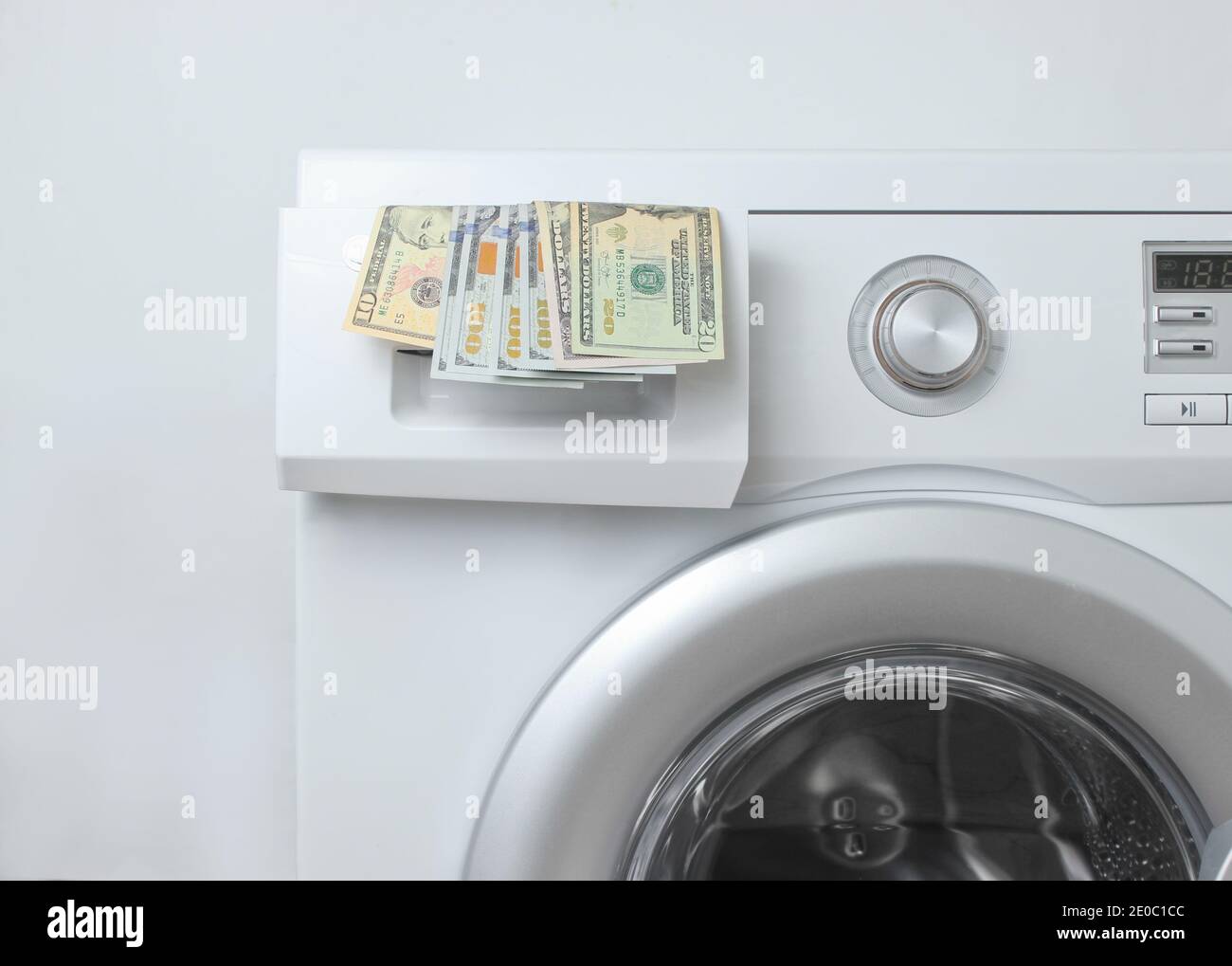 Bollette in dollari nella lavatrice su sfondo bianco. Concetto di lavaggio  costoso Foto stock - Alamy