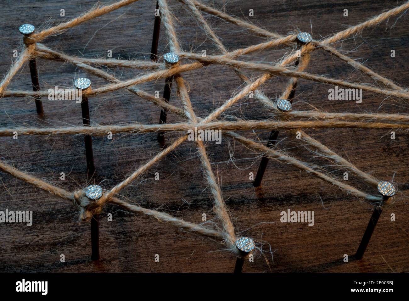 un'immagine simbolo per il lavoro di gruppo e di rete. i chiodi sono collegati da spago di iuta. tenere insieme. Foto Stock