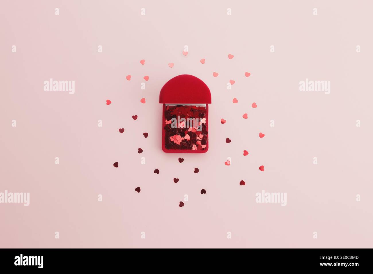Il cuore rosso brilla sullo sfondo rosa Foto Stock