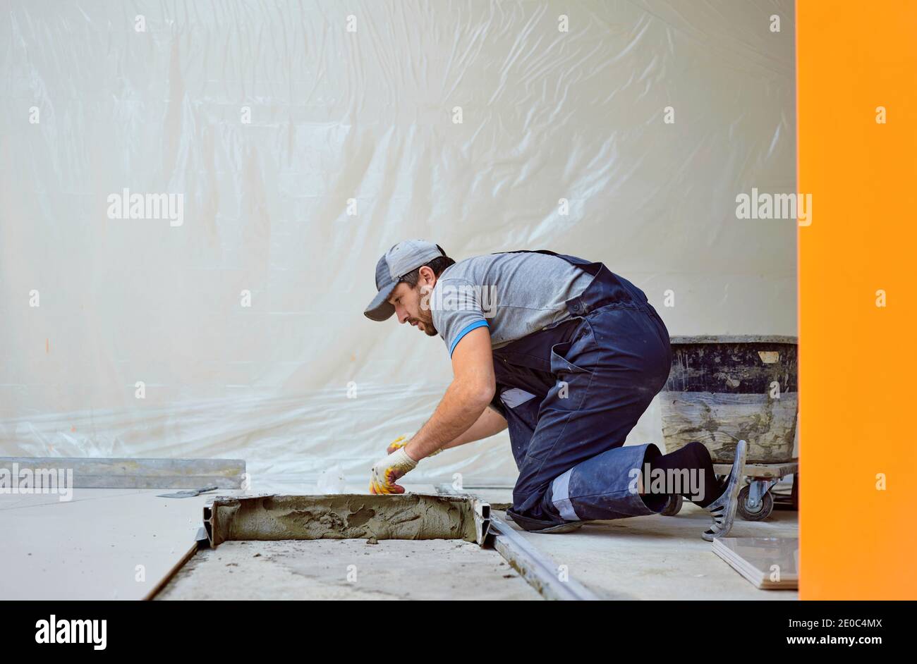 l'uomo pone il gres su un luogo di costruzione Foto Stock