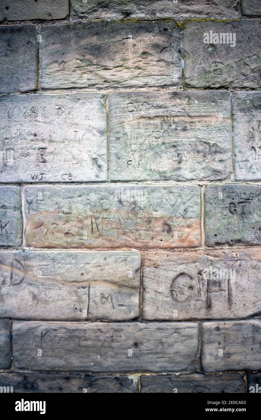 Muro di arenaria con iniziali intagliate Foto Stock