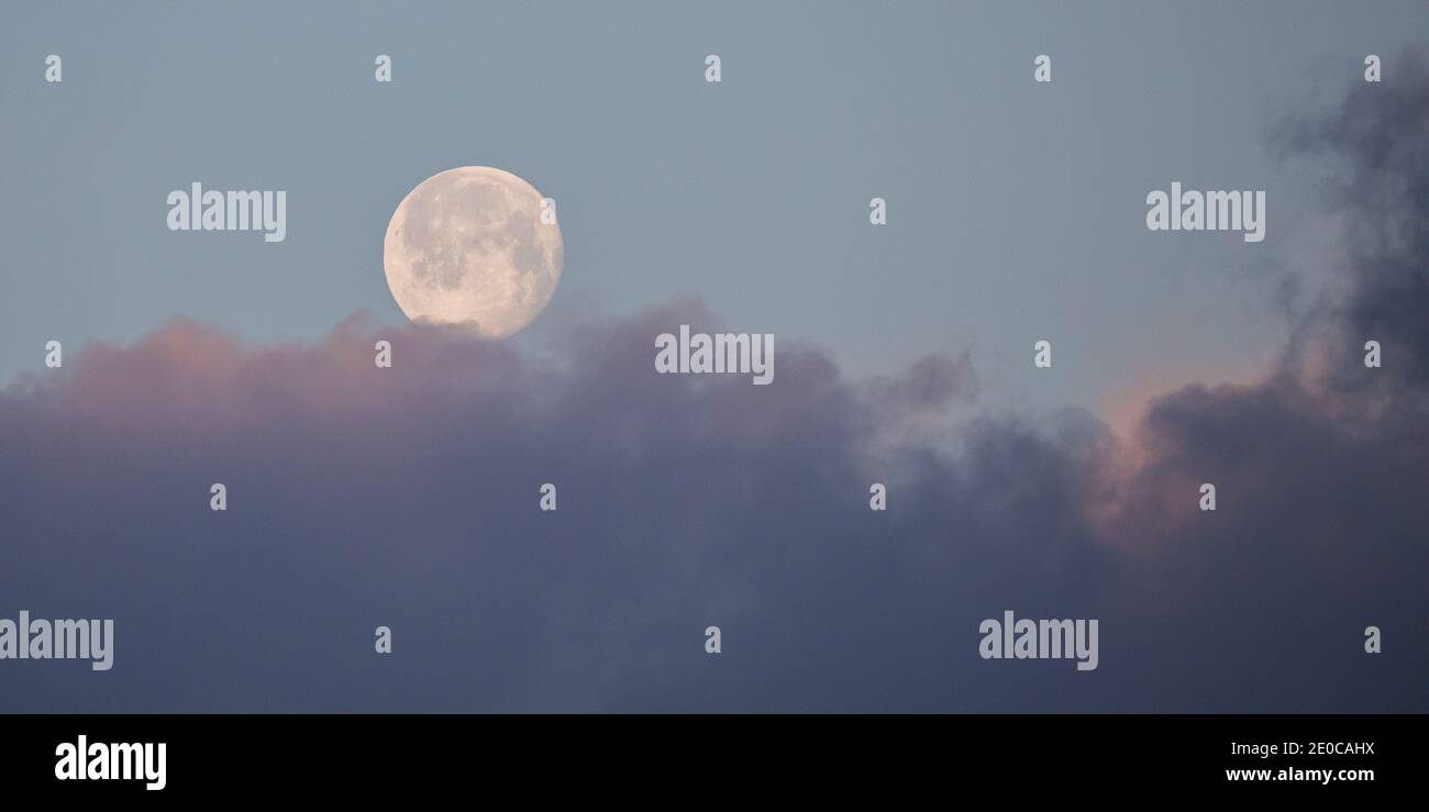 Aberystwyth, Ceredigion, Galles, Regno Unito. 31 dicembre 2020 UK Meteo: Una fredda mattina ad Aberystwyth come l'ultima luna piena nel 2020 comincia a stabilirsi, con l'alba che illumina le aree della bassa nube sopra il monumento Pendinas. Mentre la temperatura scende a meno 1 grado questa mattina sulla costa occidentale. © Ian Jones/Alamy Live News Foto Stock