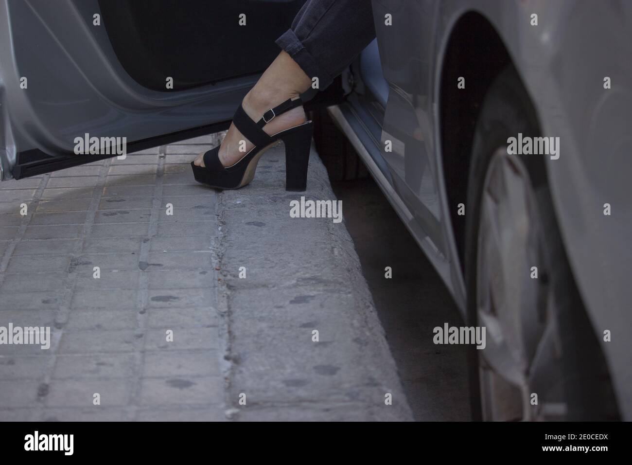 Primo piano irriconoscibile di una scarpa alta tacco di una donna di affari elegante e di successo che esce dalla sua auto per andare al lavoro. Concetto di Boss ragazza 2021. Foto Stock