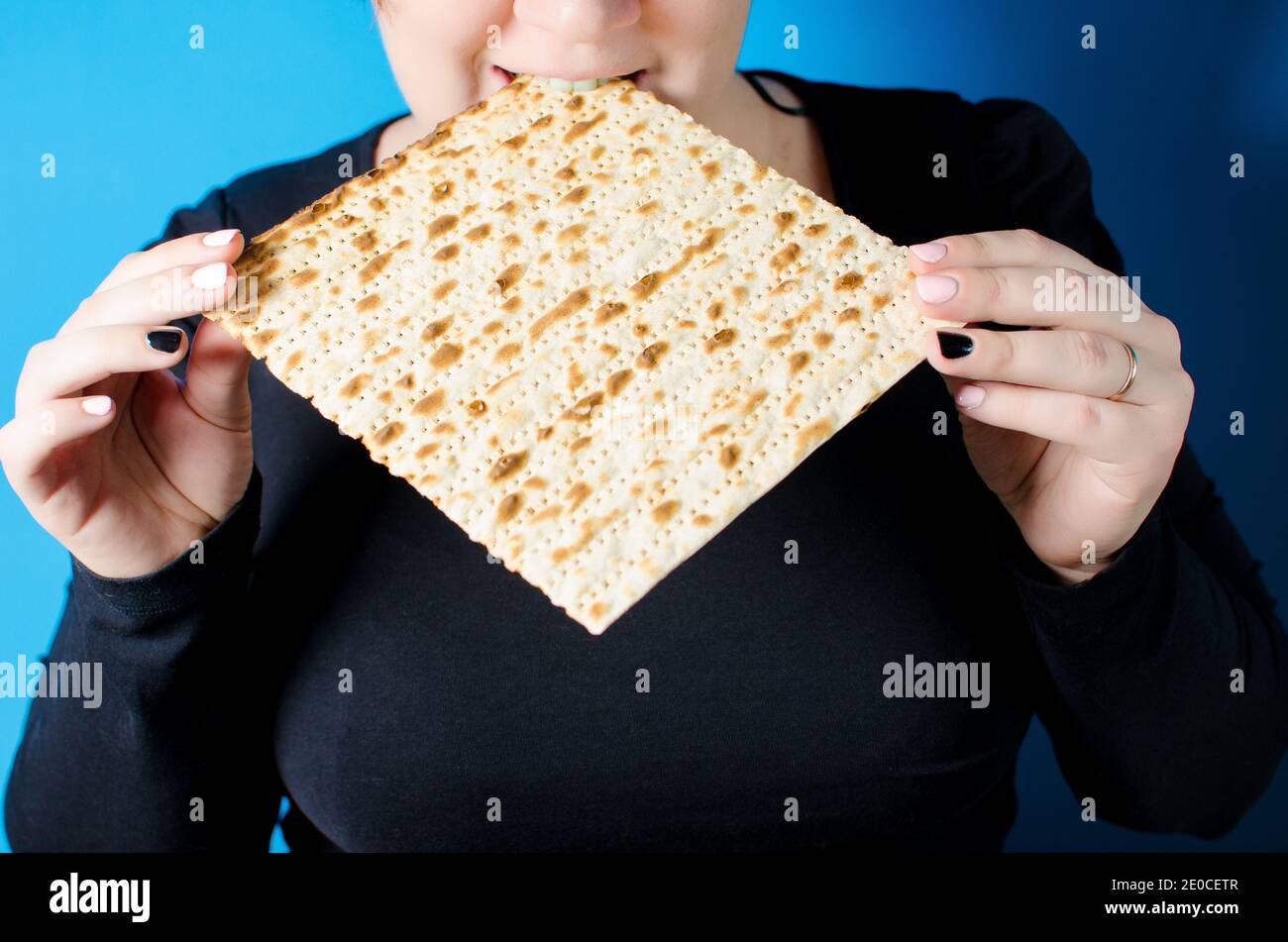 Una giovane ragazza morde il matzo. Una vacanza familiare a Pesach. Molla Foto Stock