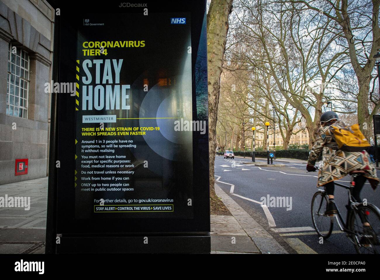 Una donna che passa accanto a un coronavirus 'Stay Home' Westminster.London è stato posto sotto le restrizioni di livello 4 come casi Sovratensione e nuovi ceppi di C. Foto Stock