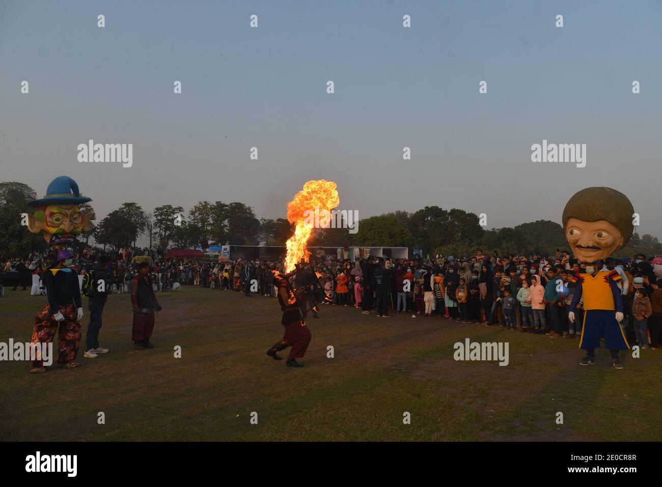 Lahore, Pakistan. 30 dicembre 2020. Pakistani un gran numero di famiglie siedono a terra partecipa al "Festival degli inverni di famiglia" al circuito automobilistico Jilani Park nella capitale provinciale Lahore. Le famiglie si divertono con il modello Dinosaur e lo spettacolo Breathing Fire from Mouth durante il "Family Winters Festival" all'ippodromo Jilani Park. (Foto di Rana Sajid Hussain/Pacific Press) Credit: Pacific Press Media Production Corp./Alamy Live News Foto Stock