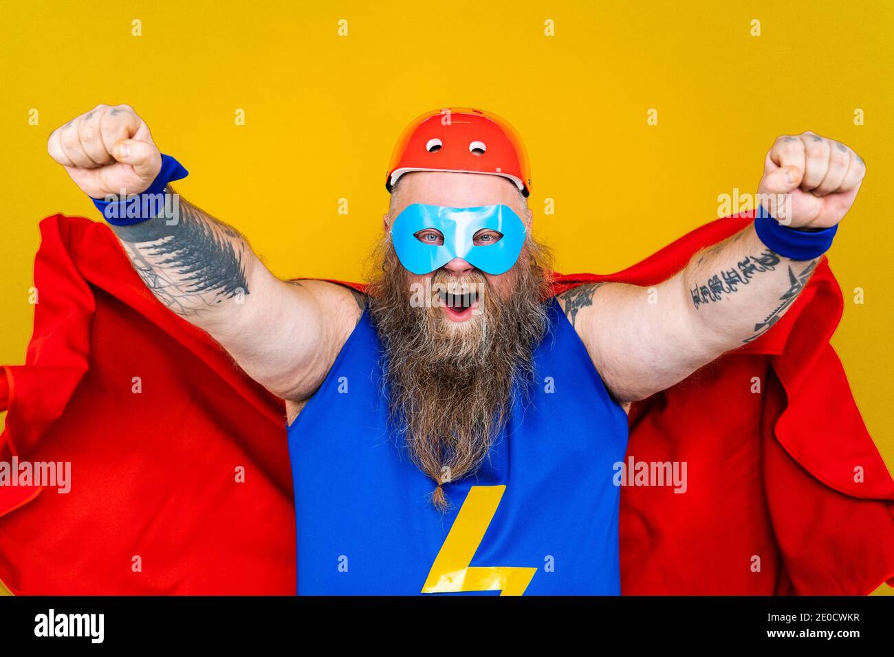 Divertente uomo grasso con costume supereroe che agisce come superumano con  poteri speciali, ritratto su sfondo colorato Foto stock - Alamy