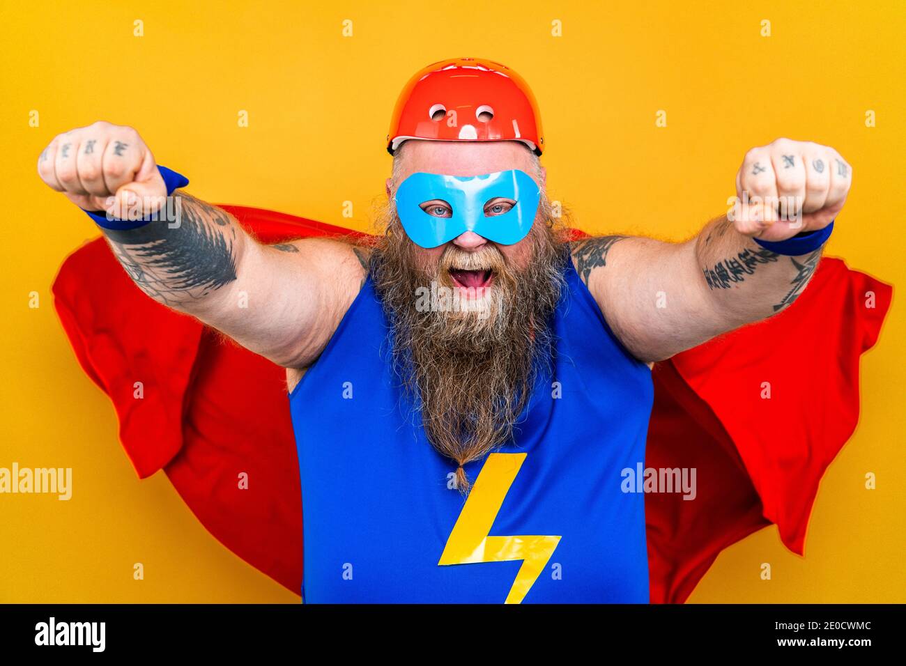 Divertente uomo grasso con costume supereroe che agisce come superumano con  poteri speciali, ritratto su sfondo colorato Foto stock - Alamy