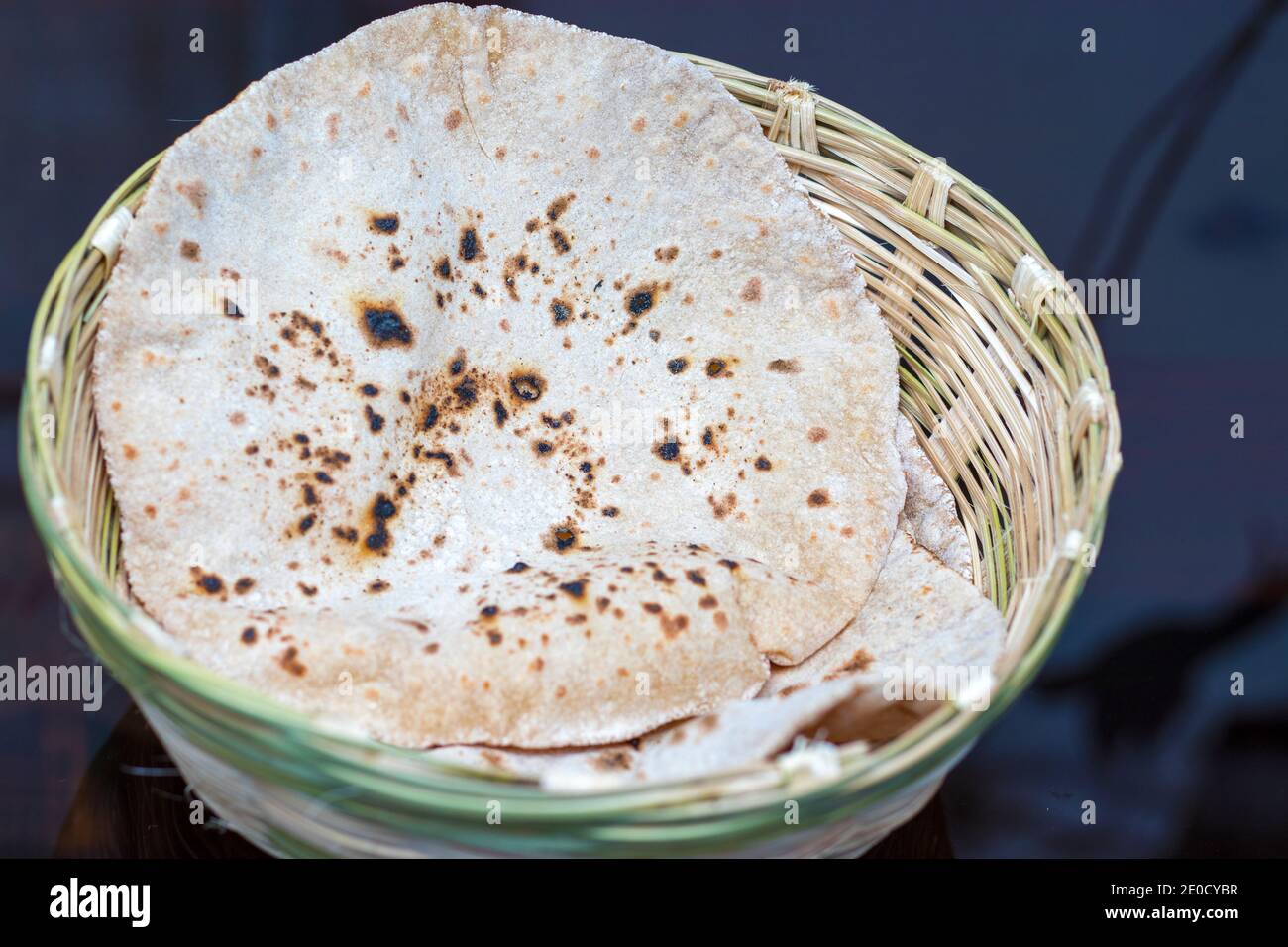 Fuoco selettivo del pane indiano Roti o Chapati con un cesto di bambù fatto a mano. Foto Stock