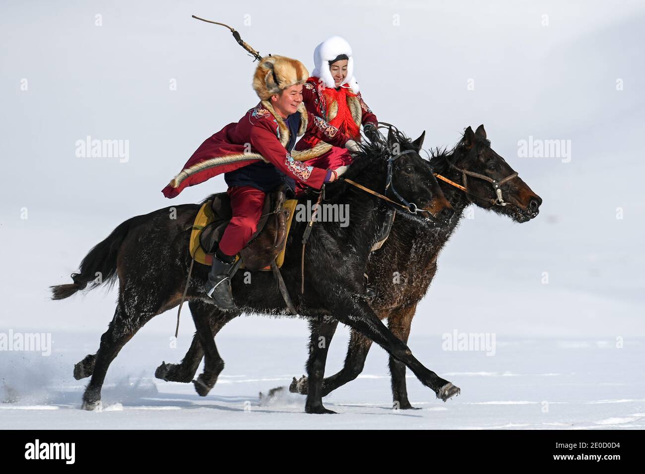 (201231) -- ZHAOSU, 31 dicembre 2020 (Xinhua) -- cavalli cavalieri cavalcano in un campo di cavalli nella Contea di Zhaosu, Prefettura autonoma di Kazak di Ili, Regione Autonoma di Xinjiang Uygur della Cina nord-occidentale, 20 dicembre 2020. Conosciuta come la città natale di una delle migliori razze di cavalli in Cina, Zhaosu si è trasformata in un'area turistica equina con viste mozzafiato dei cavalli da galoppo e degli spettacoli equestri. Con abbondanti risorse di ghiaccio e neve, Zhaosu ha anche fatto grandi sforzi per sviluppare popolari attività invernali, aiutando la gente del posto ad aumentare il reddito. (Xinhua/Ding lei) Foto Stock