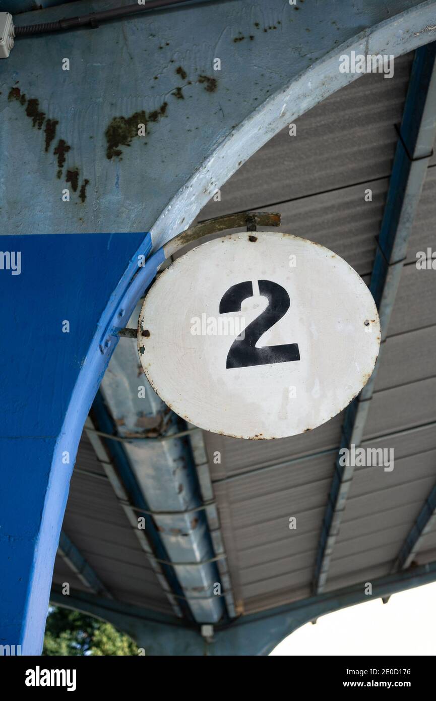Due e secondi - cifra, numero e numero. Cartello sulla piattaforma. Dettaglio e closeup di un edificio vecchio e dilapidato in cemento Foto Stock