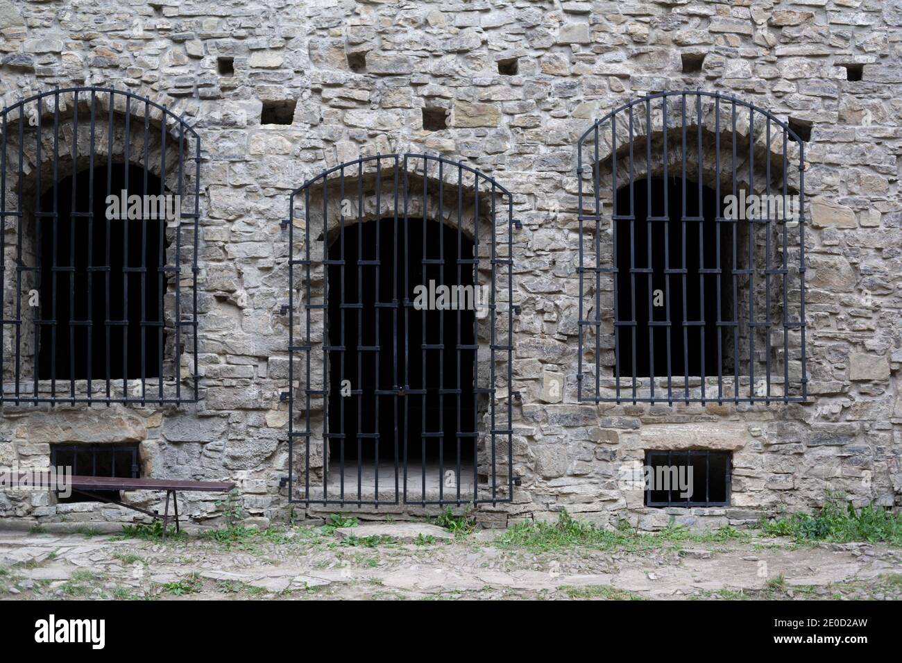 Storico carcere, prigione e prigione - vecchio, storico e antico muro di pietra. Finestre e porte con barre di ferro e griglia. Foto Stock