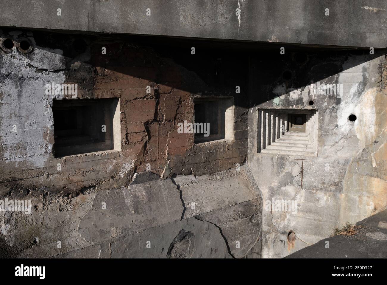 Dettaglio di bunker militare e pillbox dalla seconda guerra mondiale - abbraccio steppen e foro per pistola nella parete grigia in cemento. Foto Stock