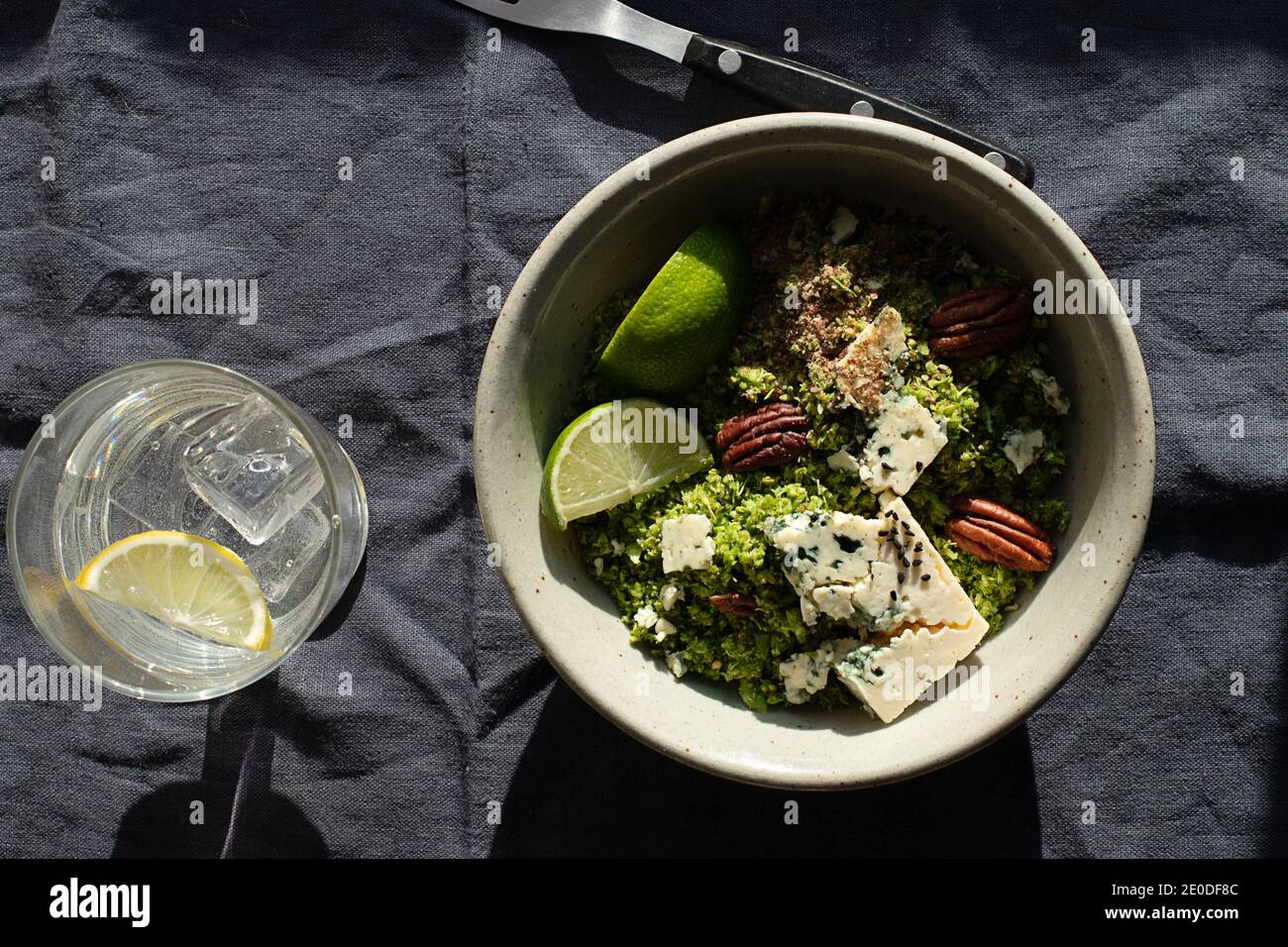 Da sopra ciotola con insalata di broccoli con couscous messo sopra tovagliolo in tessuto scuro Foto Stock