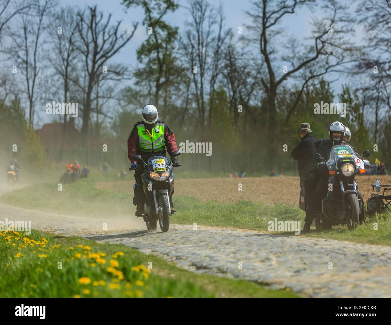 Camphin-en-Pévèle, Francia - 13 aprile 2014: Bici ufficiali che cavalcano su una strada acciottolata (Carrefour de l'Arbre) prima dell'apparizione del peloton du Foto Stock