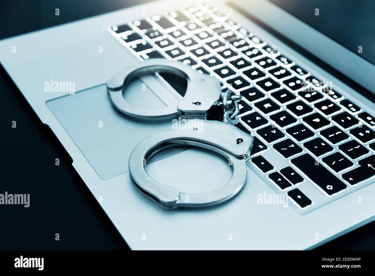 Concetto di criminalità su Internet. Manette sulla tastiera del notebook, concetto di cyber-criminalità Foto Stock