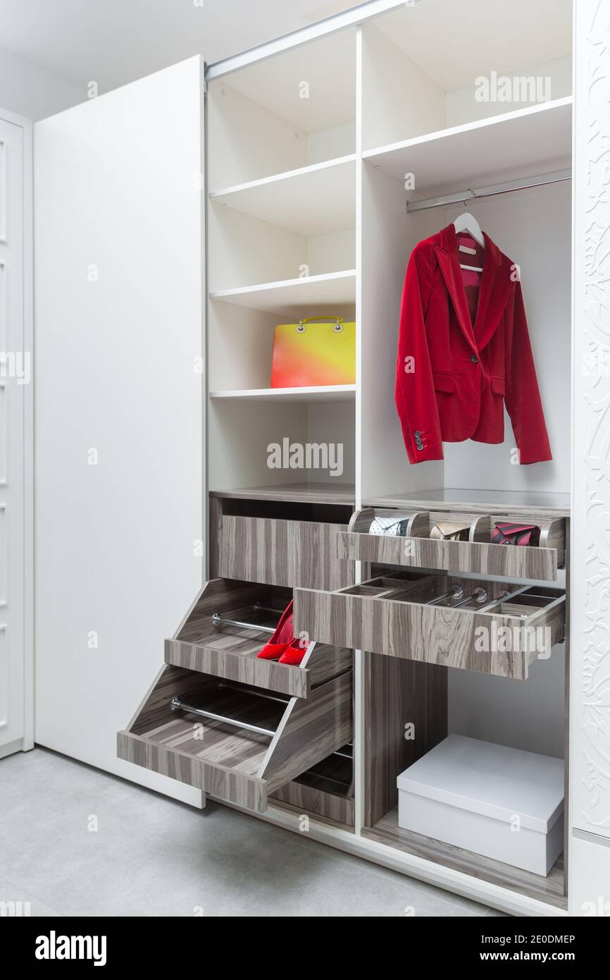 Blazer rosso donna e una borsa in un armadio bianco. Concetto di produzione di mobili Foto Stock
