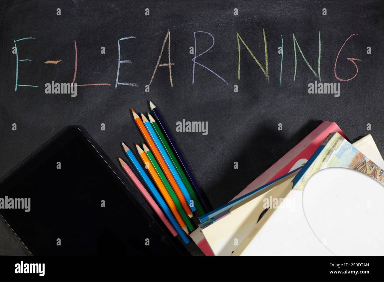 libri e tablet sulla lavagna. scuola di e-learning. Foto Stock