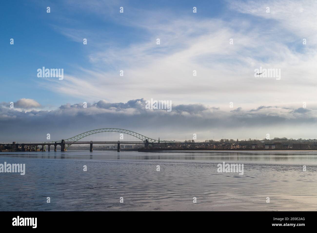Un aereo da passeggeri scende sul ponte Runcorn e sull'estuario Mersey, che si avvicina all'aeroporto di Liverpool nel dicembre 2020. Foto Stock