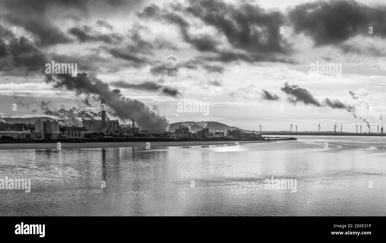 Il canale della nave di Manchester passa un angolo industriale dell'estuario di Mersey un giorno d'inverno nel dicembre 2020 sotto un cielo oscuro. Foto Stock