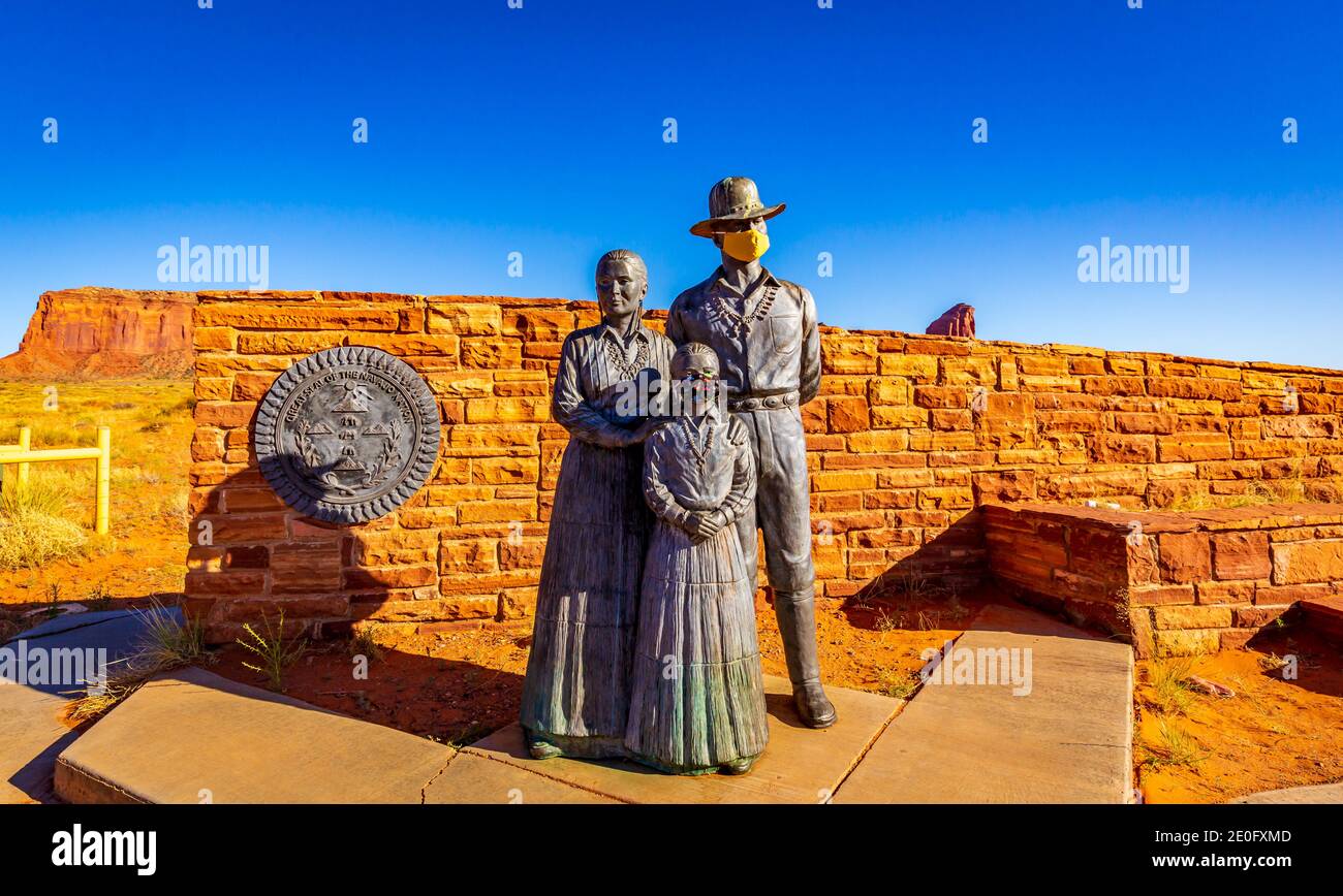 Grande Sigillo della Nazione Navajo e Statua della Famiglia Navajo di bronzo (con maschera facciale) all'ingresso della Monument Valley, chiusa a causa del COVID-19 p. Foto Stock