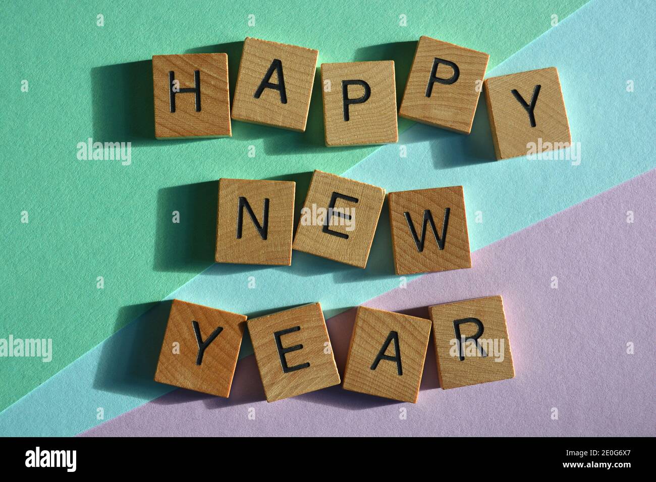 Felice anno nuovo, parole in lettere alfabetiche in legno isolate su sfondo colorato Foto Stock