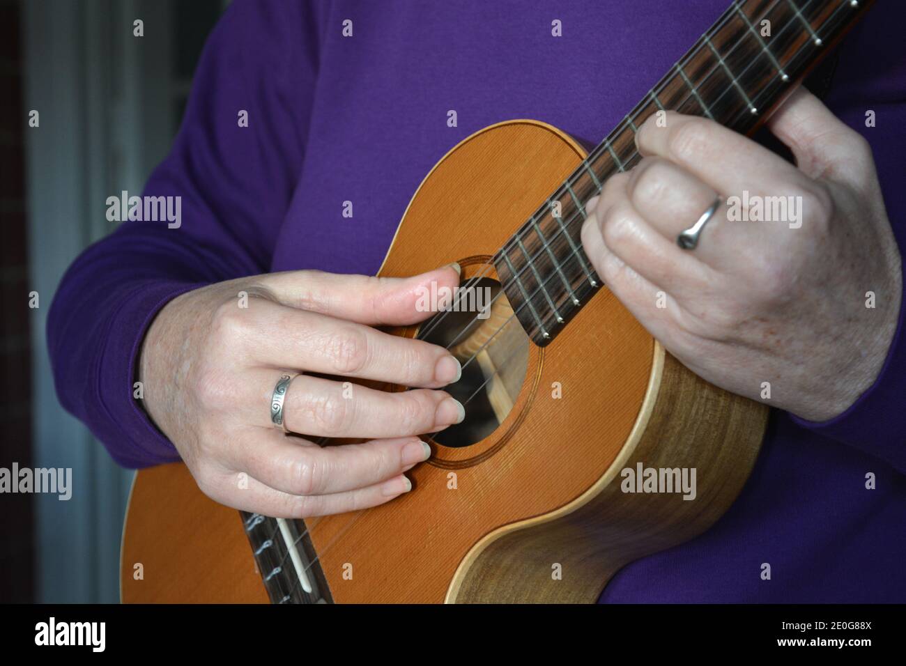 Donna che gioca un 5 corde tenore ukulele, sezione centrale, fuoco selettivo Foto Stock