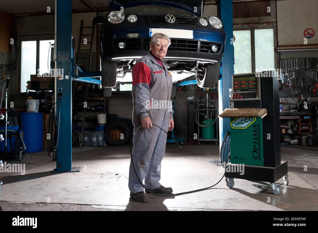 Il meccanico di automobile Mathieu Camille, 69, posa al suo garage a Echenevex, Francia nell'aprile 2012. Il garage si trova a 111 m sopra il grande Hadron Collider (LHC) del CERN. LHC è un acceleratore di particelle utilizzato dai fisici per studiare le particelle più piccole conosciute, i blocchi fondamentali di tutte le cose. TEXTE: J'ai construit ce garage it 1978. Quelques annees Plus tard, une personne est passee et nous a expique que le CERN allait construire un anneau qui passera en-dessous. Nous avons alors ete expropries du sous-sol. Nous avons reçu une Petite compensation, c'etait pas une grosse somme. ma. Mais Foto Stock