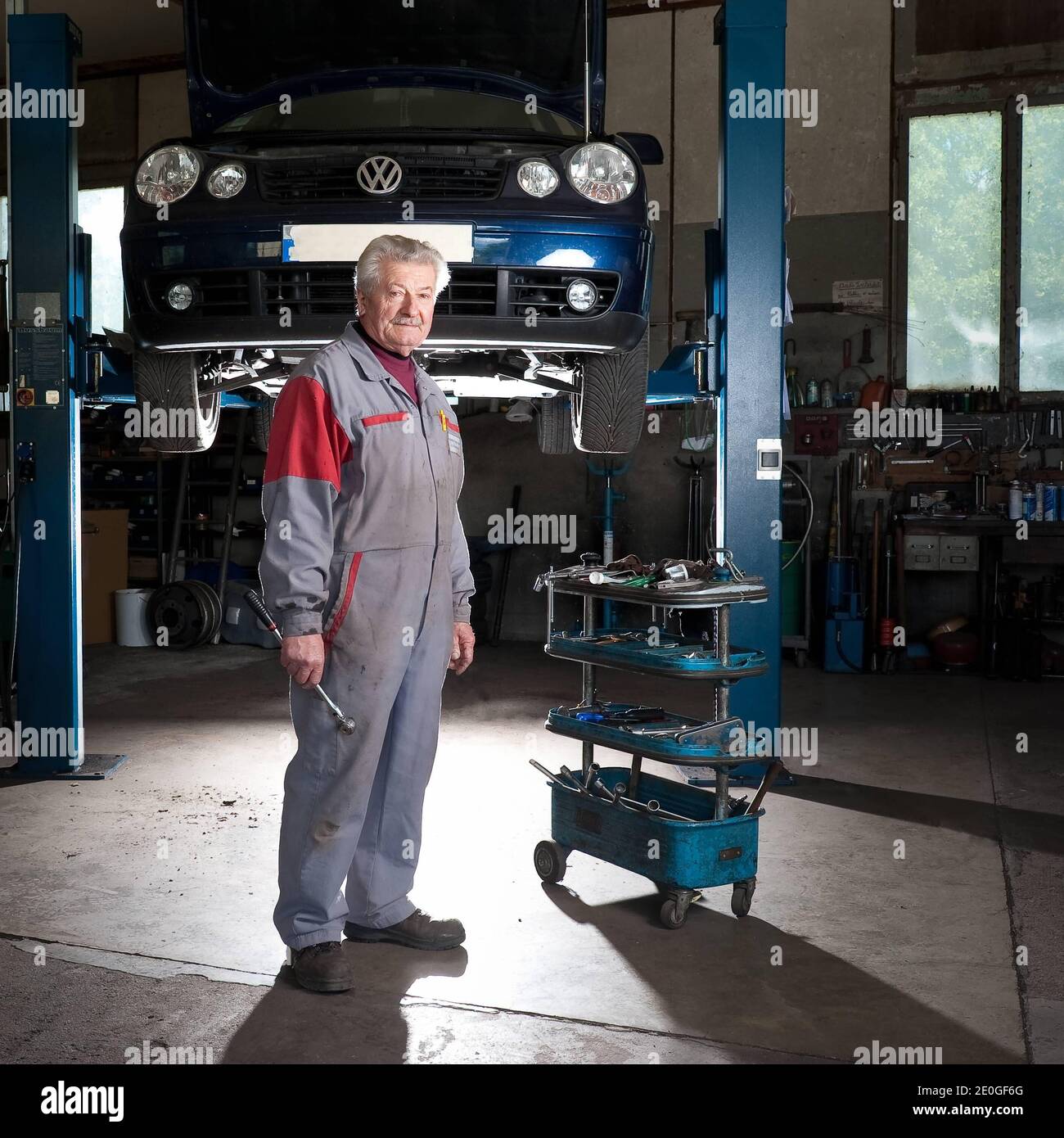 Il meccanico di automobile Mathieu Camille, 69, posa al suo garage a Echenevex, Francia nell'aprile 2012. Il garage si trova a 111 m sopra il grande Hadron Collider (LHC) del CERN. LHC è un acceleratore di particelle utilizzato dai fisici per studiare le particelle più piccole conosciute, i blocchi fondamentali di tutte le cose. TEXTE: J'ai construit ce garage it 1978. Quelques annees Plus tard, une personne est passee et nous a expique que le CERN allait construire un anneau qui passera en-dessous. Nous avons alors ete expropries du sous-sol. Nous avons reçu une Petite compensation, c'etait pas une grosse somme. ma. Mais Foto Stock