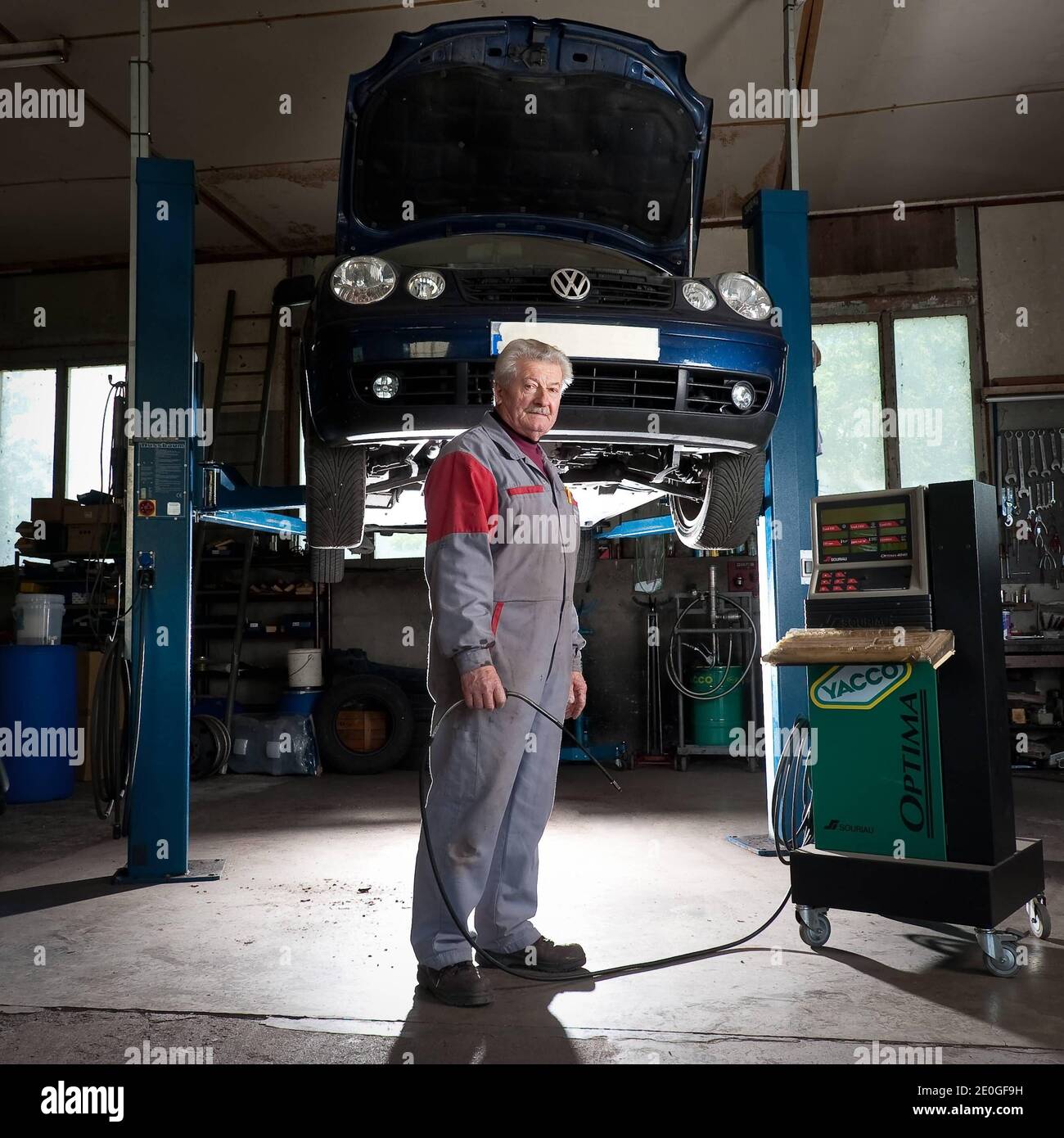 Il meccanico di automobile Mathieu Camille, 69, posa al suo garage a Echenevex, Francia nell'aprile 2012. Il garage si trova a 111 m sopra il grande Hadron Collider (LHC) del CERN. LHC è un acceleratore di particelle utilizzato dai fisici per studiare le particelle più piccole conosciute, i blocchi fondamentali di tutte le cose. TEXTE: J'ai construit ce garage it 1978. Quelques annees Plus tard, une personne est passee et nous a expique que le CERN allait construire un anneau qui passera en-dessous. Nous avons alors ete expropries du sous-sol. Nous avons reçu une Petite compensation, c'etait pas une grosse somme. ma. Mais Foto Stock