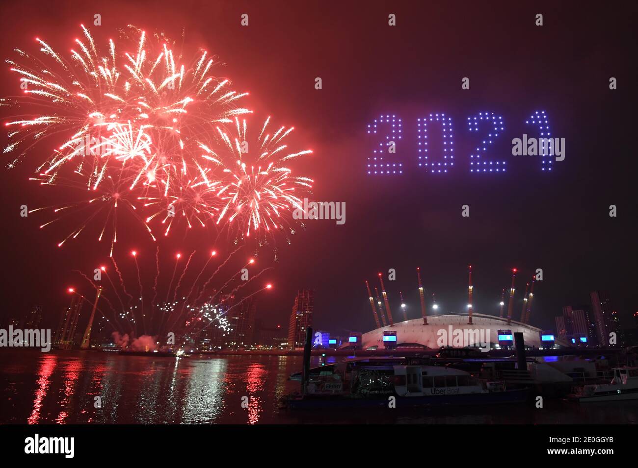 Fuochi d'artificio e droni illuminano il cielo notturno sull'O2 di Londra, formando un'esposizione luminosa, poiché la normale esposizione di fuochi d'artificio di Capodanno di Londra è stata annullata a causa della pandemia del coronavirus. Foto Stock