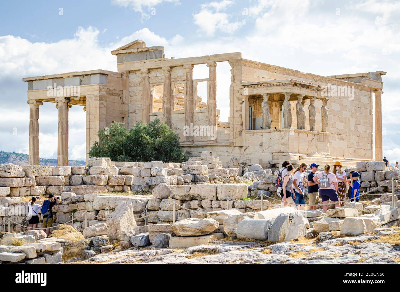 Turisti al portico dei Cariatidi e Erechtheion dietro le rovine di pietra del vecchio tempio di Atena, Acropoli, Atene, Grecia Foto Stock