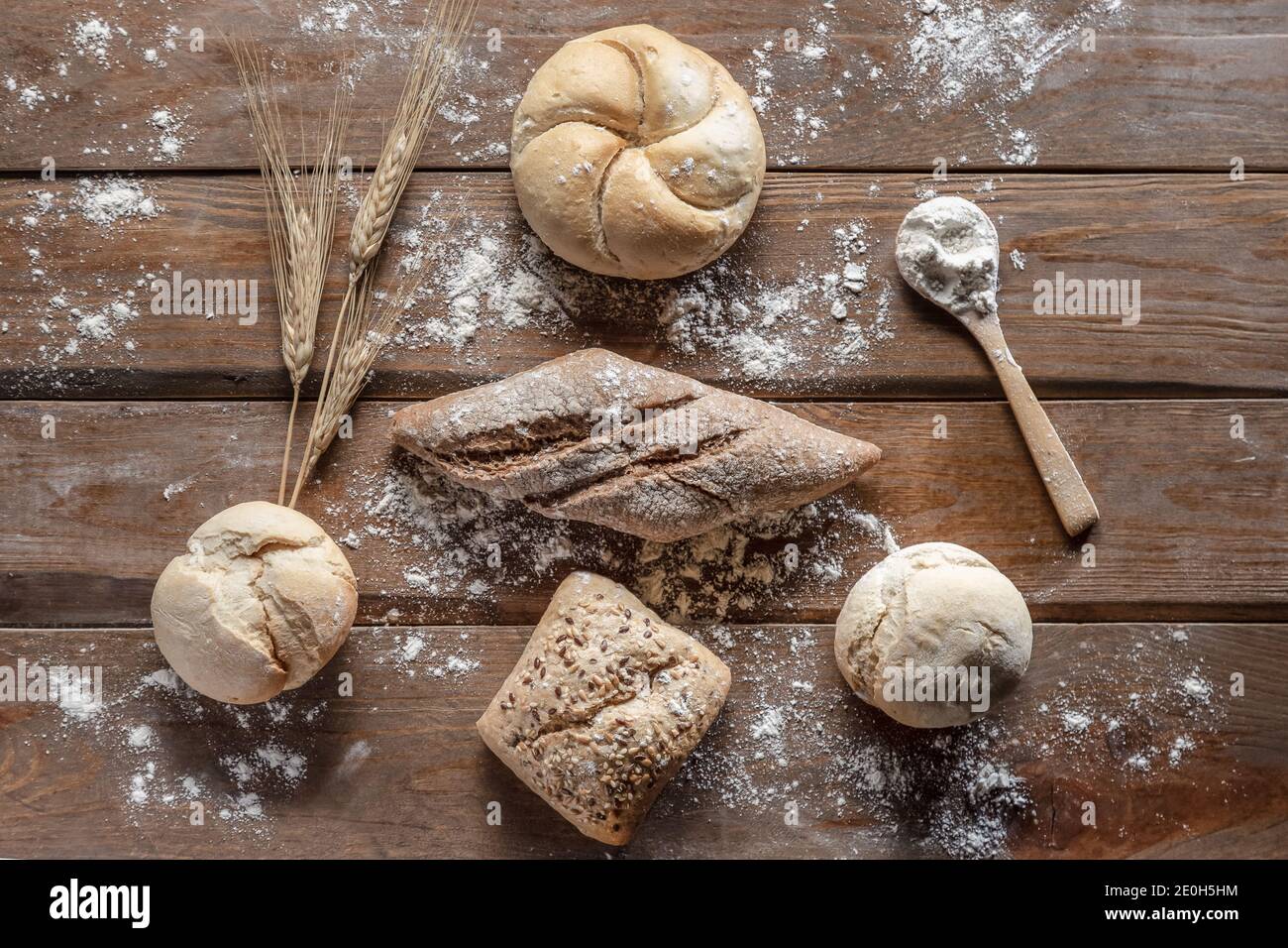 pane con spighe di grano e farina su tavola di legno, vista dall'alto Foto Stock