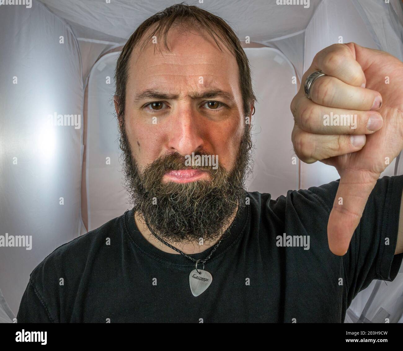 Un uomo bearded che mostra il disprezzo e le umbra giù Foto Stock