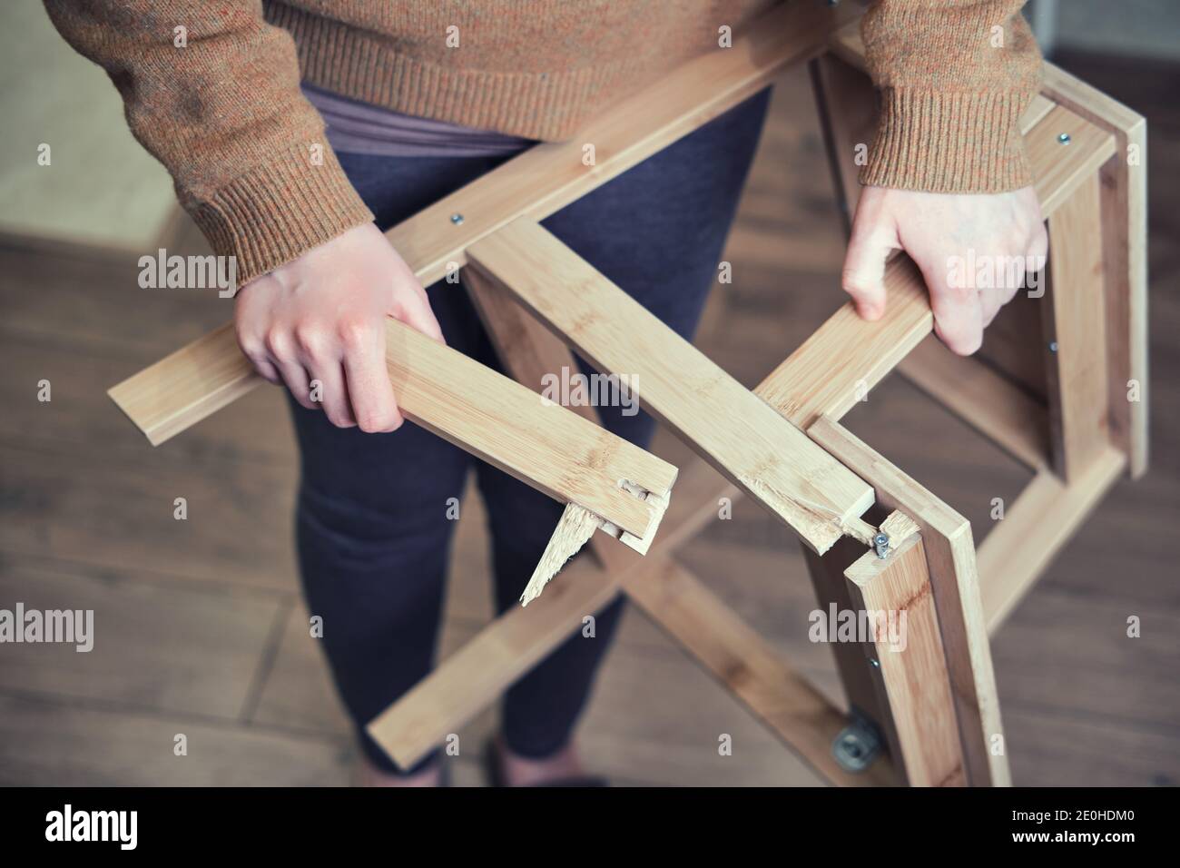 Gamba della sedia di legno rotto alla base. Scala rotta nelle mani della  donna. Problemi di sicurezza sul lavoro a casa Foto stock - Alamy