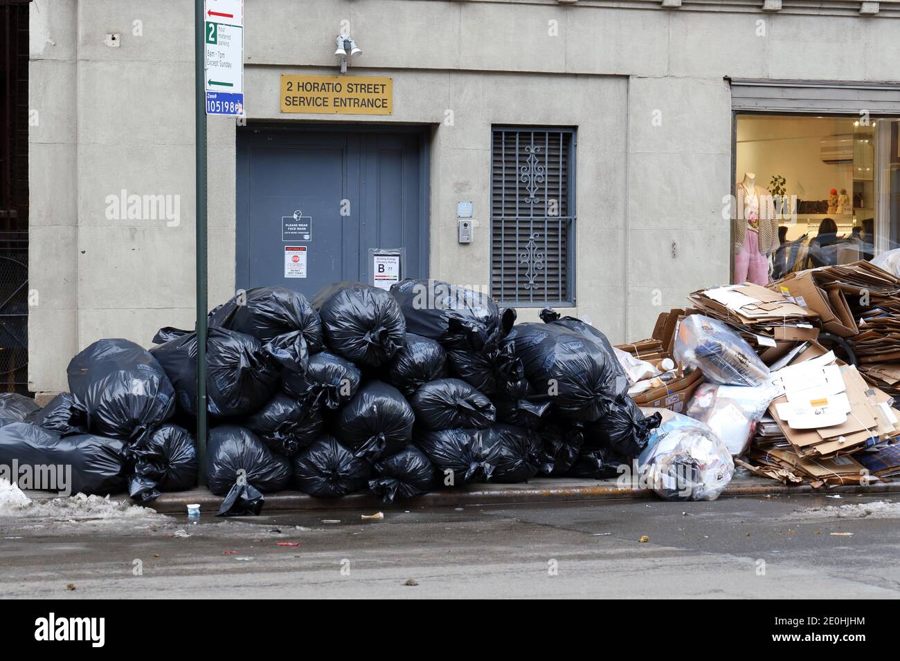 Un piccolo mucchio di rifiuti residenziali e di riciclaggio sul marciapiede in attesa del prelievo da parte del Dipartimento di Sanitation di New York Foto Stock