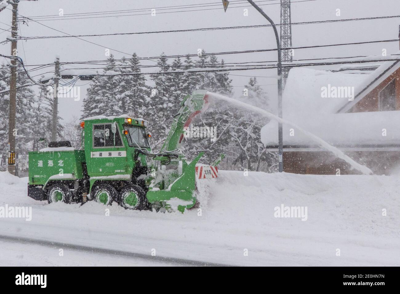 Una macchina spazzaneve che sgomenta le strade dopo una forte tempesta di neve in Giappone Foto Stock
