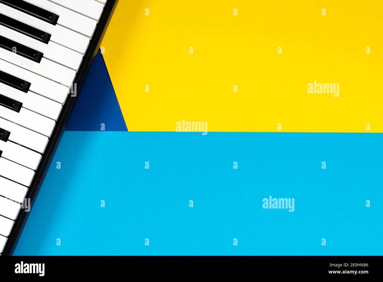 Vista dall'alto al pianoforte su sfondo giallo e blu. Concetto di apprendimento musicale. Vista dall'alto Foto Stock