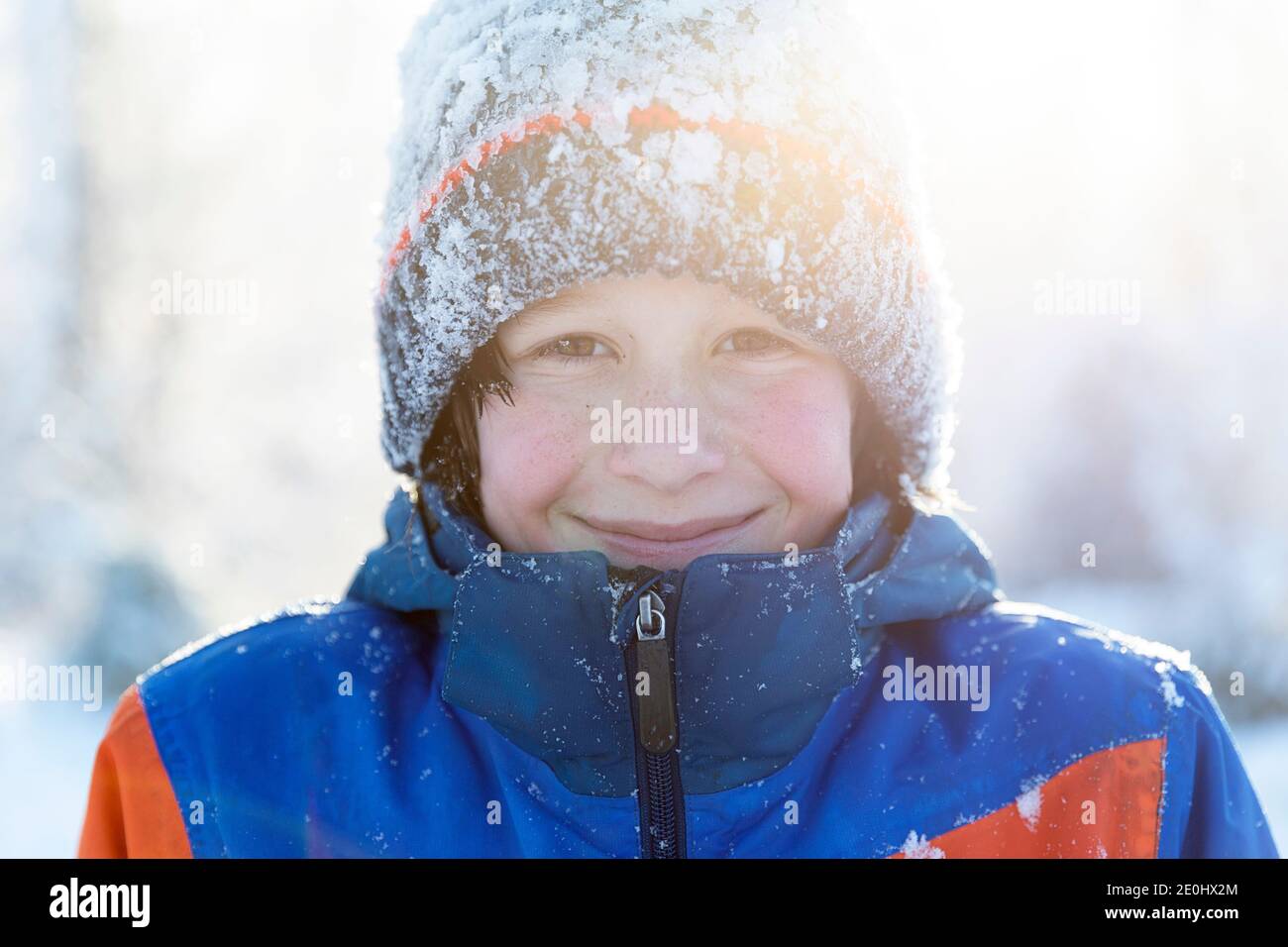 Ritratto invernale di un ragazzo sorridente nella neve Foto Stock