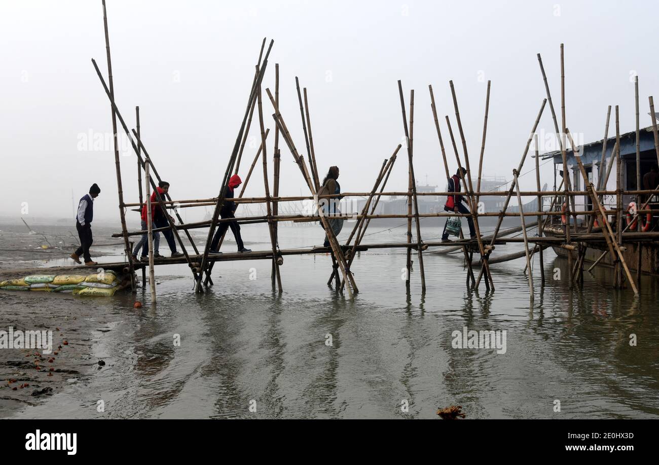 31 dicembre 2020, Guwahati, Assam, India: La gente cammina attraverso un ponte di bambù per salire a bordo di una nave nel fiume Brahmaputra in una mattinata foggy a Guwahati Assam India venerdì 1 gennaio 2021. Il fiume Brahmaputra è uno dei fiumi più grandi dell'Asia, che scorre dalla regione cinese del Tibet ed entra in India (immagine di credito: © Dasarath Deka/ZUMA Wire) Foto Stock