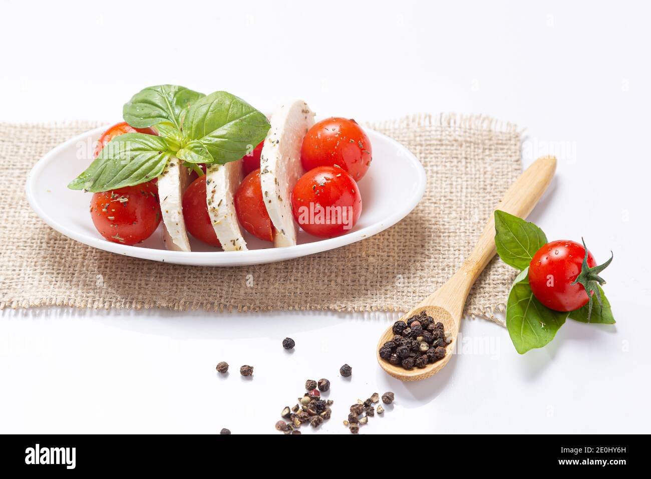 Mozzareela, pomodoro e basilico, su sfondo bianco. Dieta mediterranea e concetto di cibo sano. Foto Stock