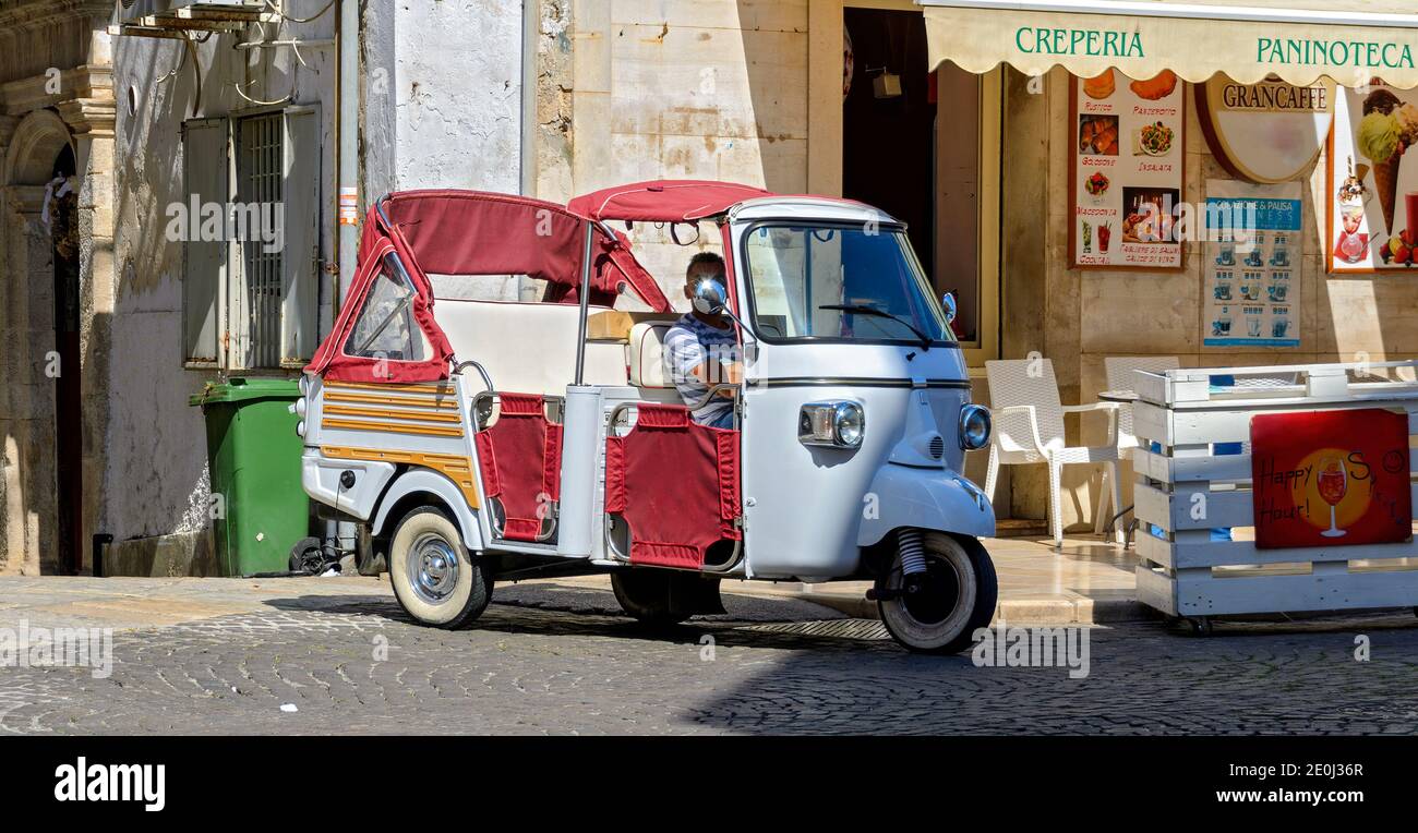 Veicolo a tre ruote con cofano aperto convertibile in attesa di passeggeri nel villaggio di Ostuni, Italia Foto Stock