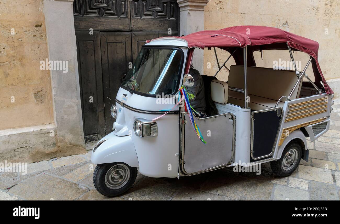Veicolo a tre ruote con cofano chiuso convertibile nel villaggio di Matera, Italia Foto Stock