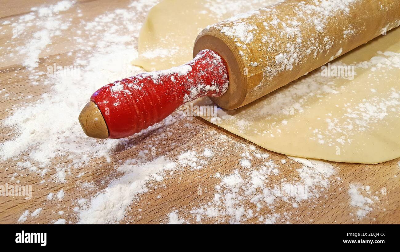 Primo piano di legno retrò Rolling pin sulla crosta torta con farina bianca Foto Stock