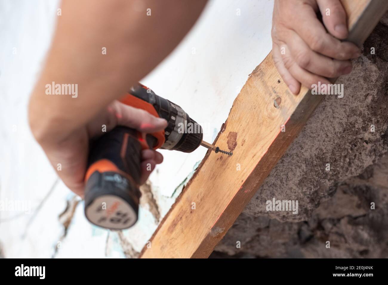 la procedura guidata inserisce la vite nella scheda con un cacciavite elettrico. Ristrutturazione di abitazioni, costruzione Foto Stock