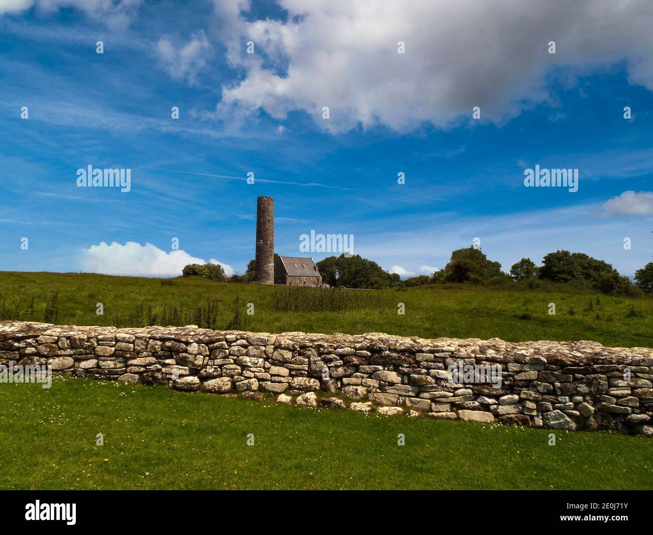 Resti di un sito monastico medievale con la torre rotonda e la chiesa in pietra. Foto Stock