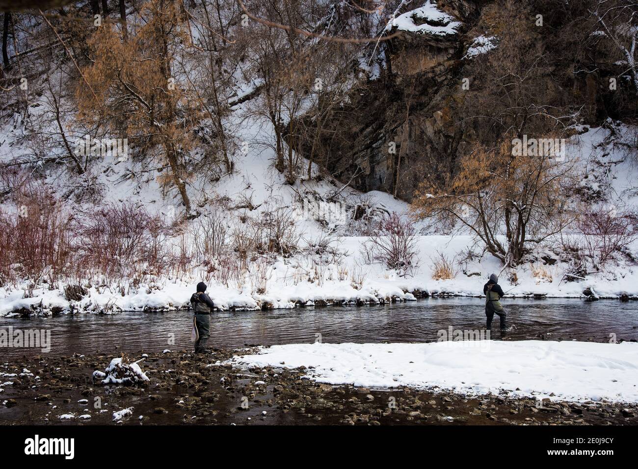 Fly pescatore, la pesca nelle acque fredde dell'inverno. Passione e interesse per lo sport sono necessari in queste temperature frigide. Foto Stock