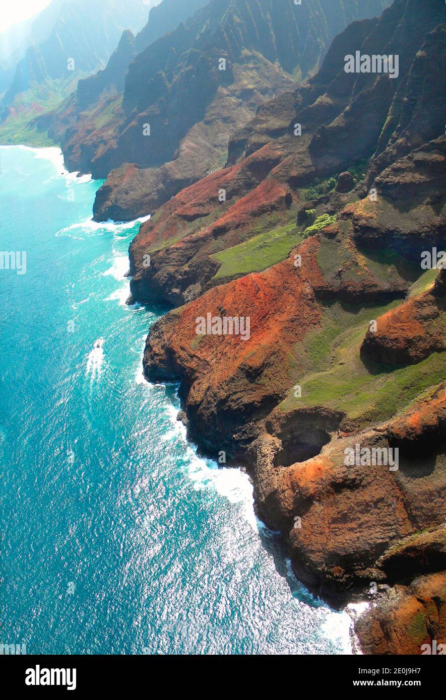 Una delle coste più spettacolari del mondo. Un tetto di grotta di mare crollato può essere visto in primo piano. La barca trimarana dà scala. Foto Stock